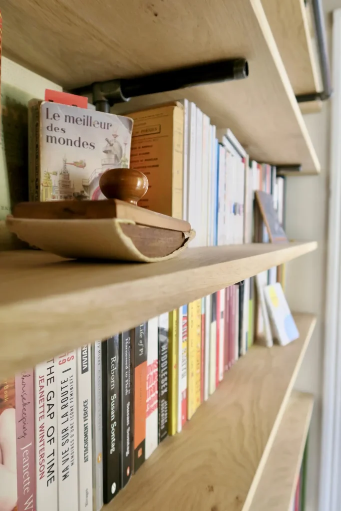 bibliothèque en chêne massif et acier. On voit ici le détail des tube en acier qui contraste avec la chaleur du chêne.