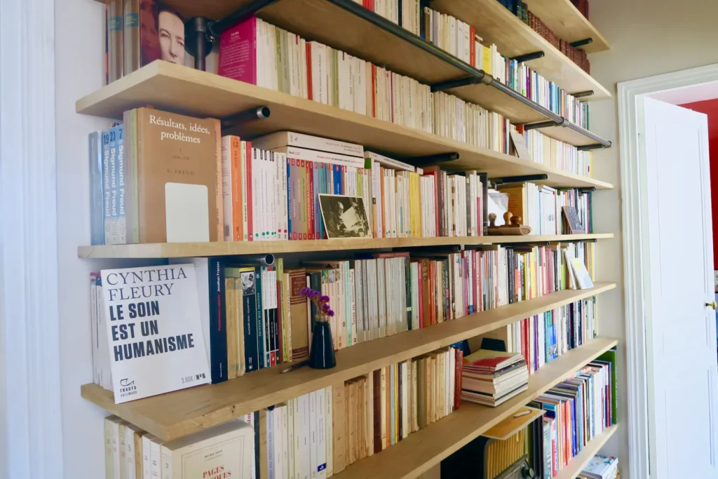 La bibliothèque sur mesure en bois et métal met en valeur les livres bien rangés.